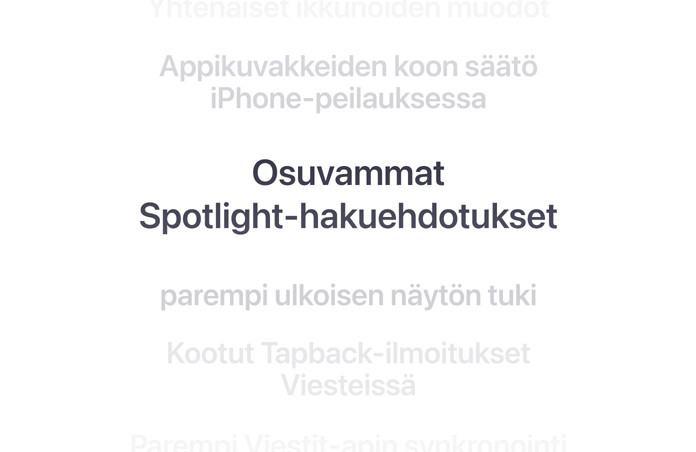 Pystysuuntainen luettelo ominaisuuksista, keskellä lihavoituna ”Better Spotlight search suggestions”. Ylä- ja alapuolella olevat ympäröivät ominaisuudet häivyttyvät taustaan.