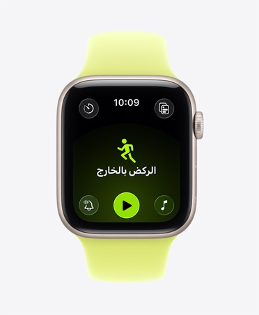 Apple Watch SE 3 بإطار من الألومنيوم بلون ضوء النجوم، وتمرين الركض بالخارج مفتوح، وعناصر التحكم في التشغيل داخل تطبيق Apple Music في أسفل الشاشة، وحزام رياضي بلون أصفر نيون