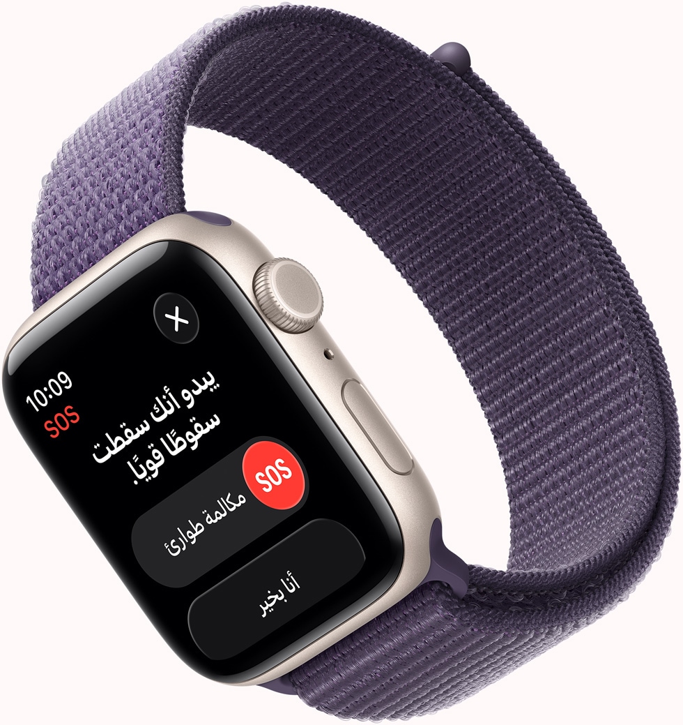 Apple Watch SE 3 بإطار من الألومنيوم ولون ضوء النجوم، وإشعار SOS لميزة اكتشاف السقوط، وزر مكالمة طوارئ وزر أنا بخير، والجزء الخارجي الأيمن يُظهر التاج الرقمي والميكروفون والزر الجانبي، وحزام Loop رياضي بلون ليلكي ضبابي