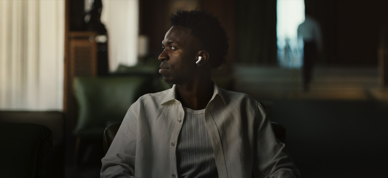 شخص يرتدي قميصاً أبيض، رأسه موجه إلى الجانب، سماعة AirPods Pro 3 اليسرى ظاهرة