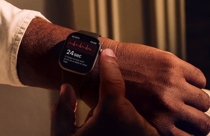 Osoba przyciskająca i przytrzymująca pokrętło Digital Crown na Apple Watch Series 11, aby sprawdzić dane dotyczące zdrowia serca w aplikacji EKG