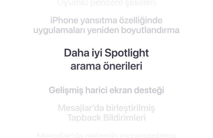 Dikey bir özellikler listesi, ortada kalın harflerle “Daha iyi Spotlight arama önerileri” gösteriliyor. Etrafındaki diğer özellikler arka planda aşağı ve yukarı doğru silikleşiyor.