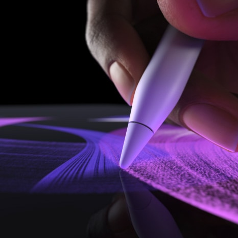 Une personne utilise l’Apple Pencil  Pro dans Procreate pour tracer un trait de pinceau d’une couleur éclatante