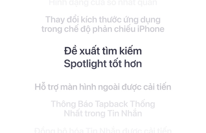 Một danh sách các tính năng theo chiều dọc, với “Gợi ý tìm kiếm Spotlight tốt hơn” được hiển thị in đậm ở giữa. Các tính năng xung quanh mờ dần vào nền phía trên và dưới.